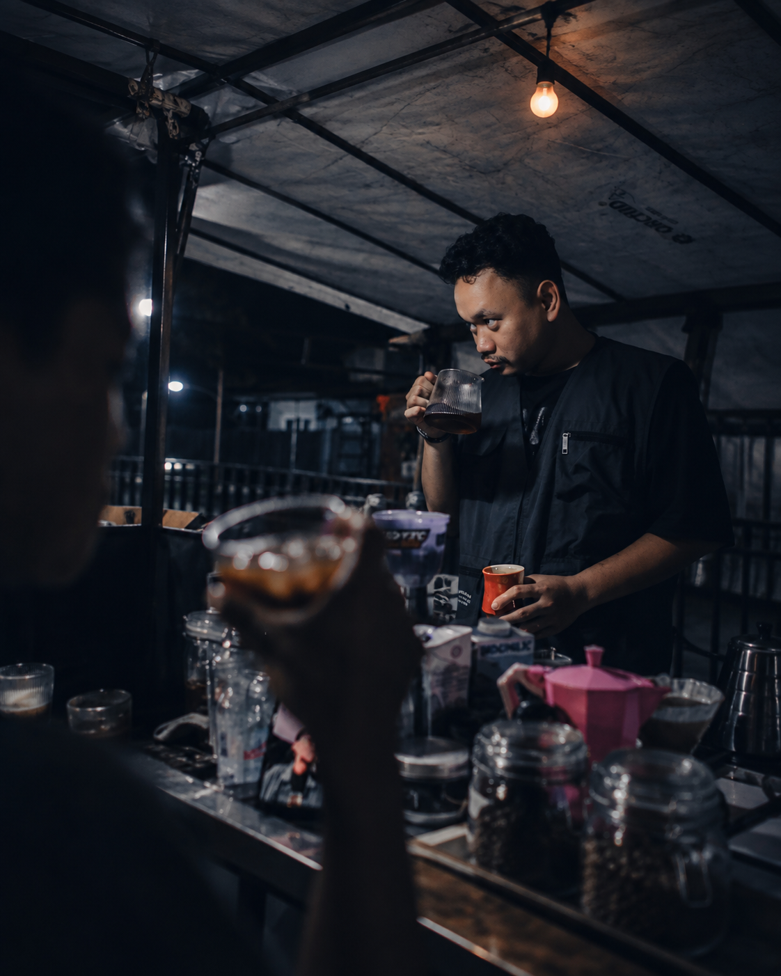 Suasana proses seduh dan orang-orang di gerobak Lowcost pada malam hari